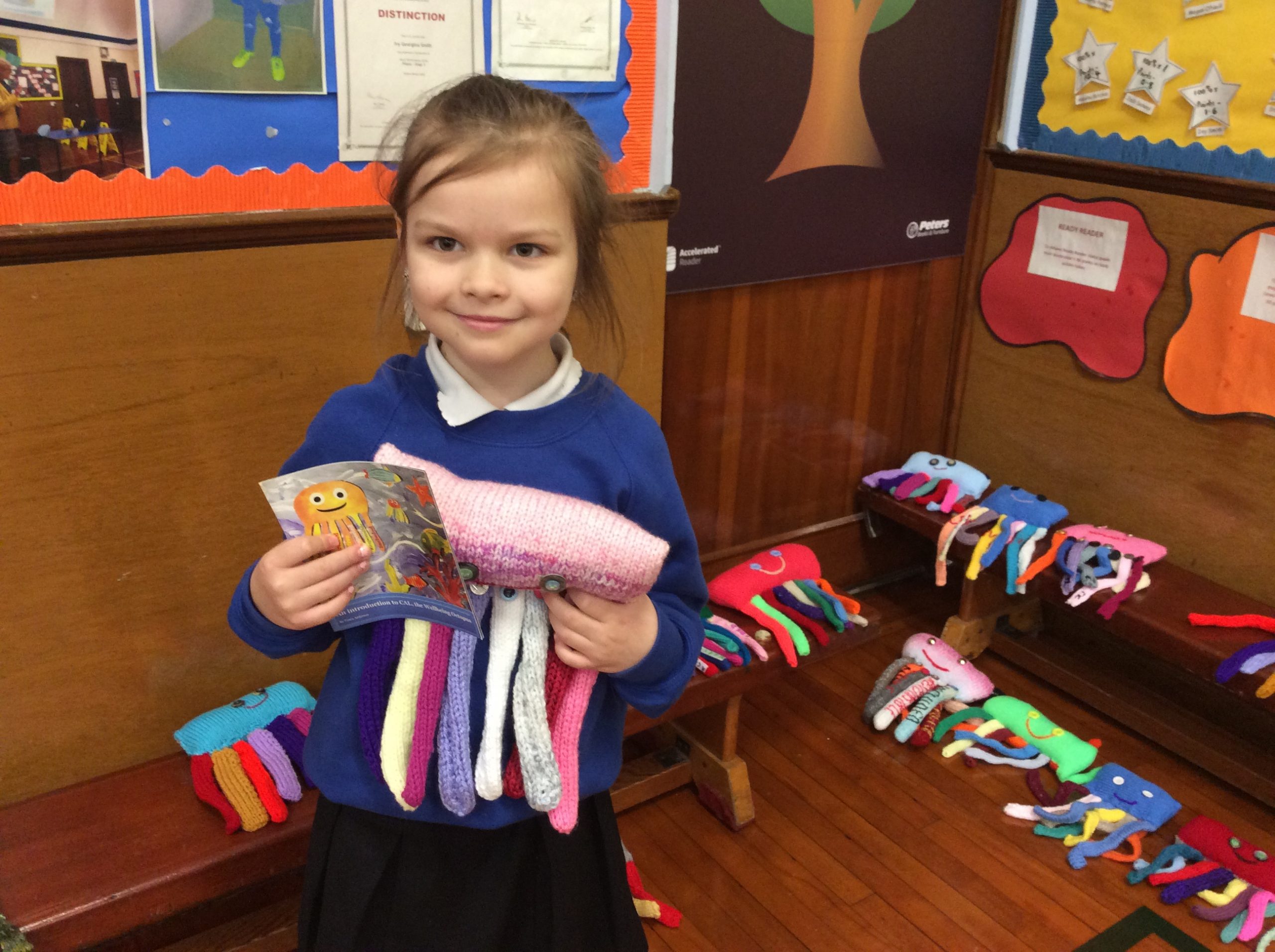 A young child discovering a knitted CAL wellbeing octopus in an everyday shop setting