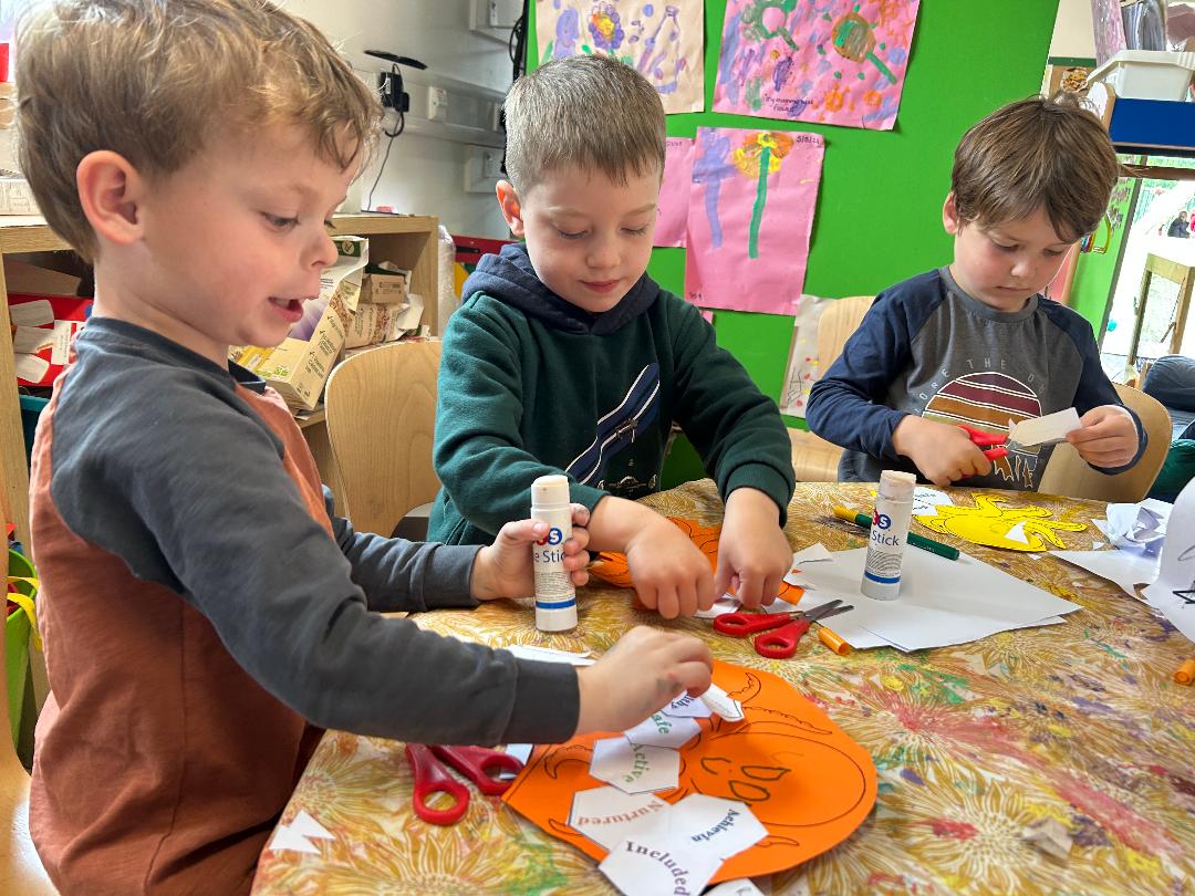Children holding knitted BUTTER and Friends characters during a school activity